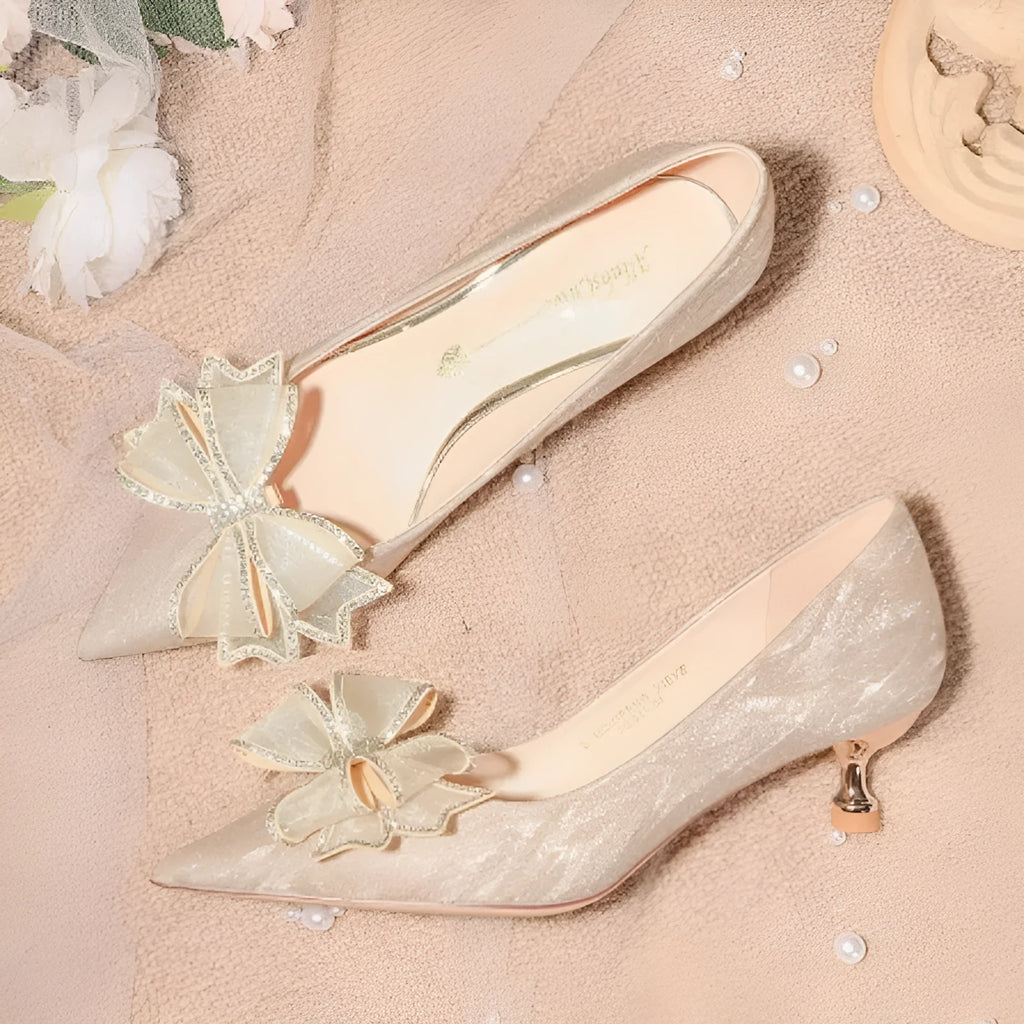 Champagne coloured sequinned pointed toe stiletto high heel pump on a white background.