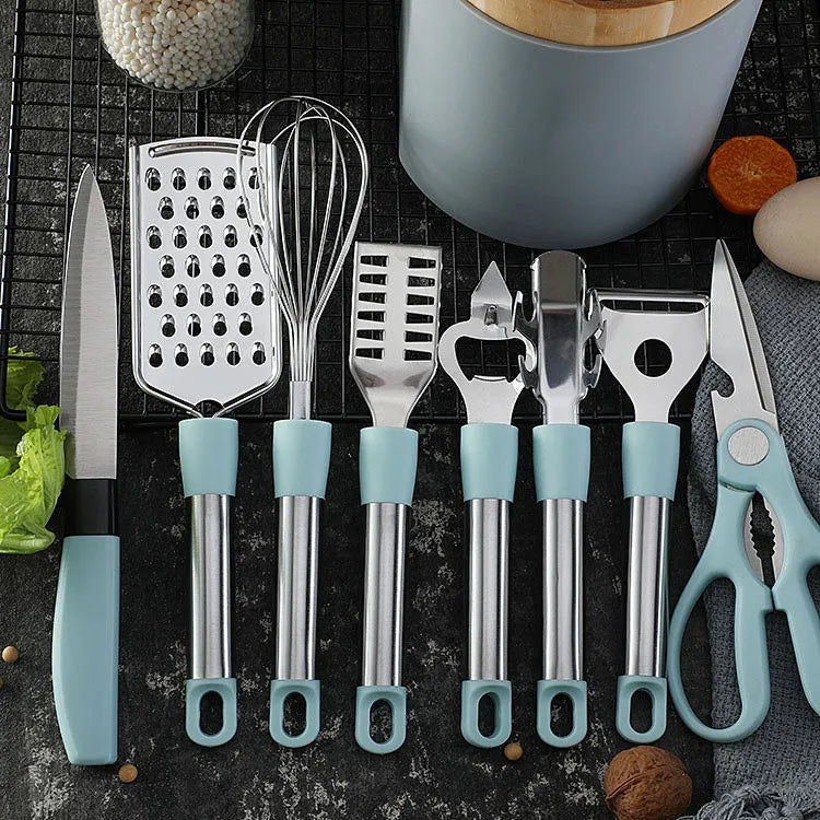 Stainless steel kitchen gadget set with peeler and whisk on grey tray