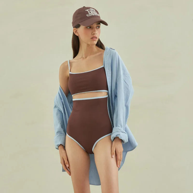 Brown women's one-piece swimsuit with a triangle pattern top on a hanger.