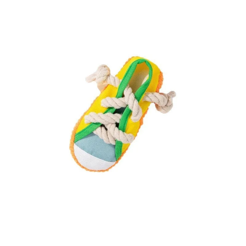 A rock yellow plastic dog chew toy shaped like a slipper, designed for biting and making sound.