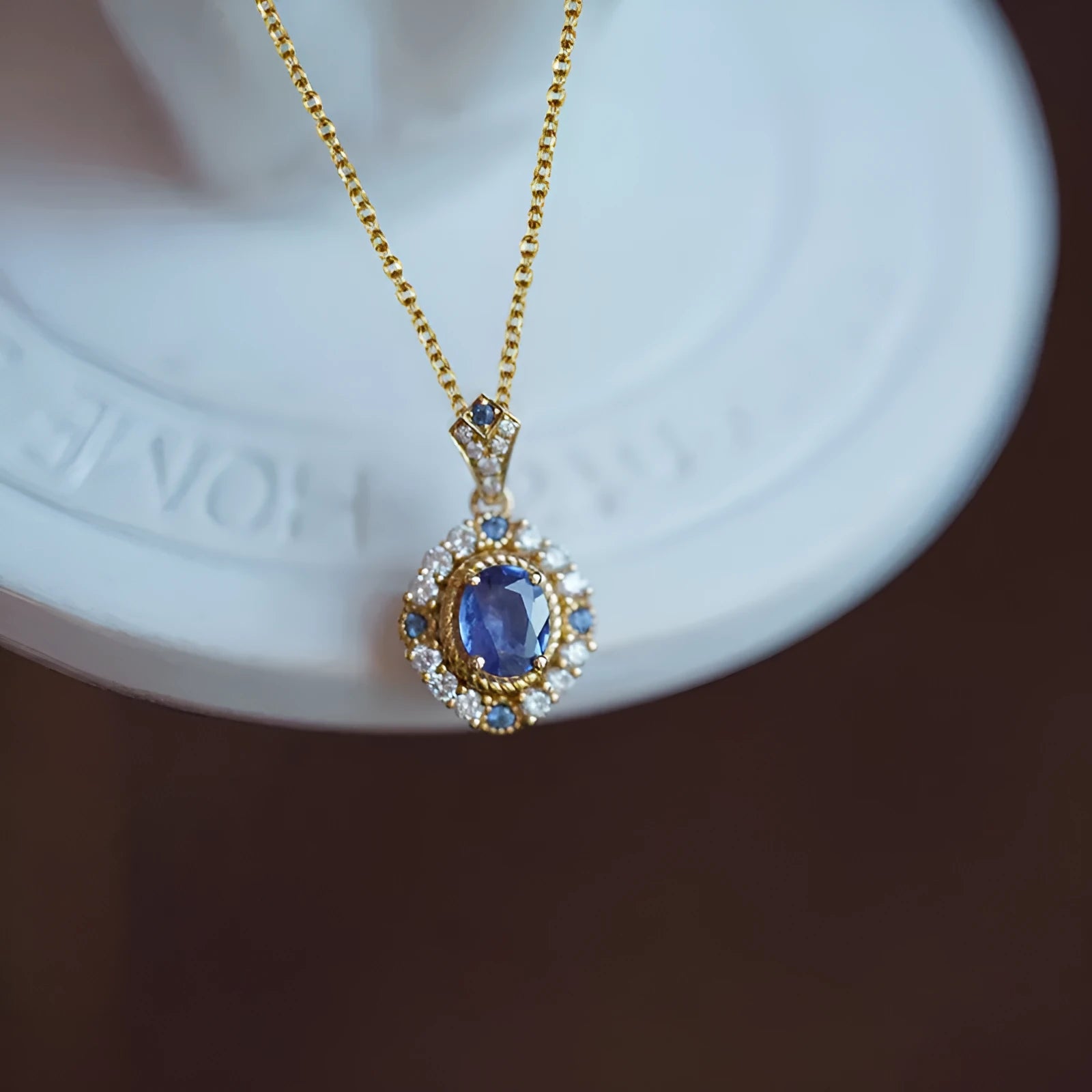 Golden copper necklace with a mixed gemstone inlaid pendant on a box chain.