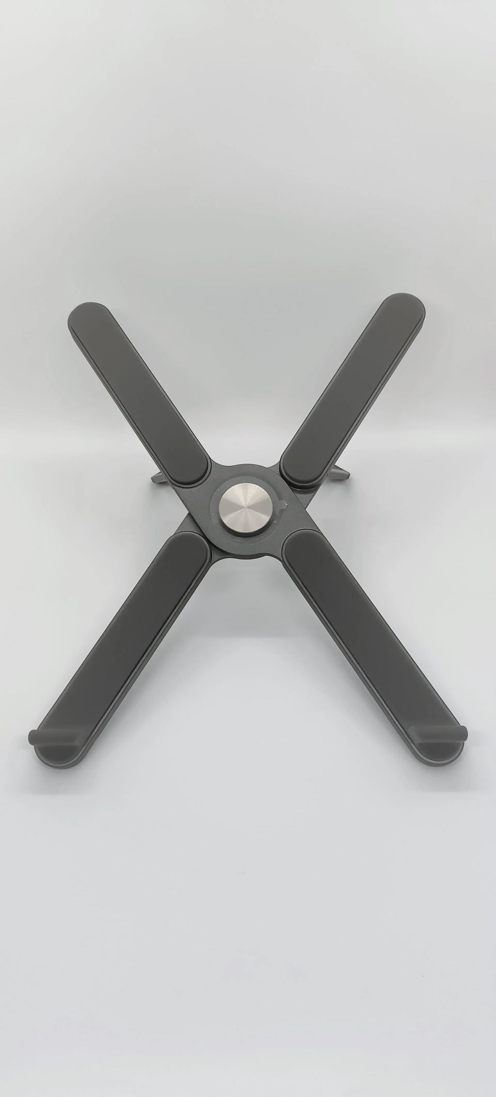 Foldable aluminium alloy laptop bracket in silver raised on a desk surface