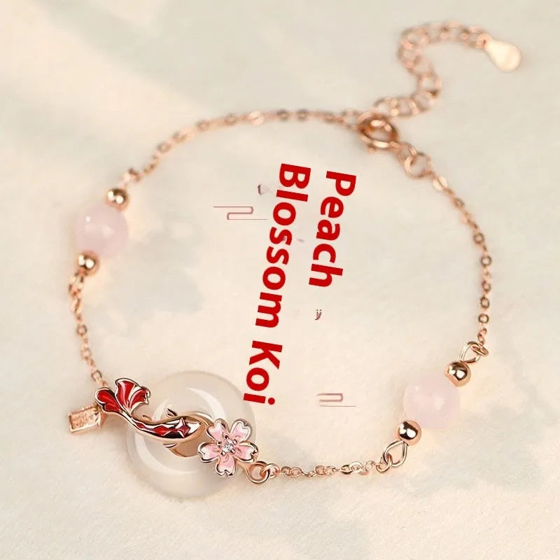 Close-up of a women's S925 sterling silver bracelet with a floral geometric shape, white chalcedony crystal, and a detailed Koi fish motif.