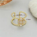 Copper open ring with gold plating and adjustable U-shaped design on a finger.