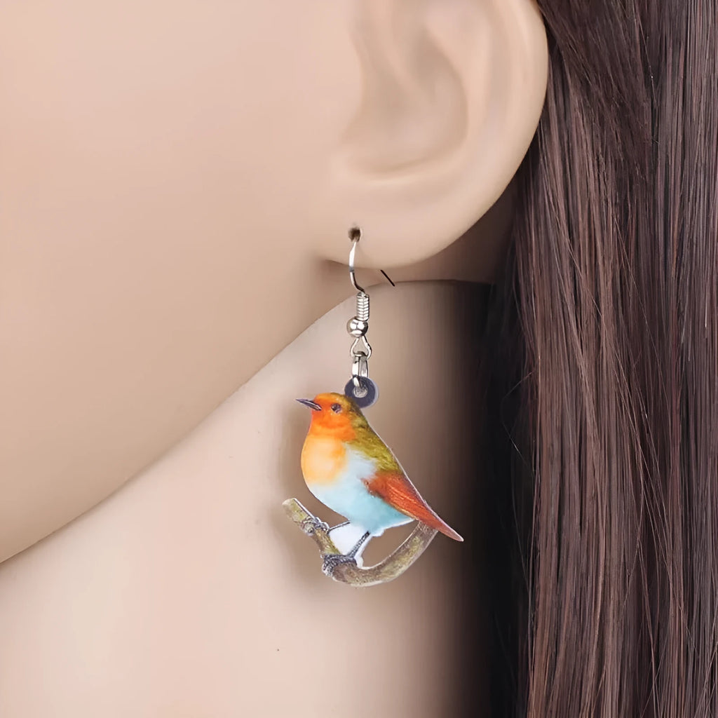 Acrylic blue titmouse bird and snake design pendant earrings on a white background.