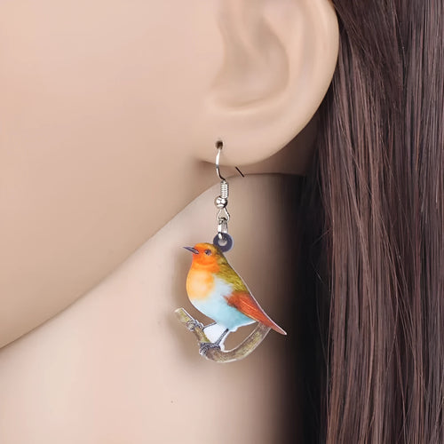 Acrylic blue titmouse bird and snake design pendant earrings on a white background.