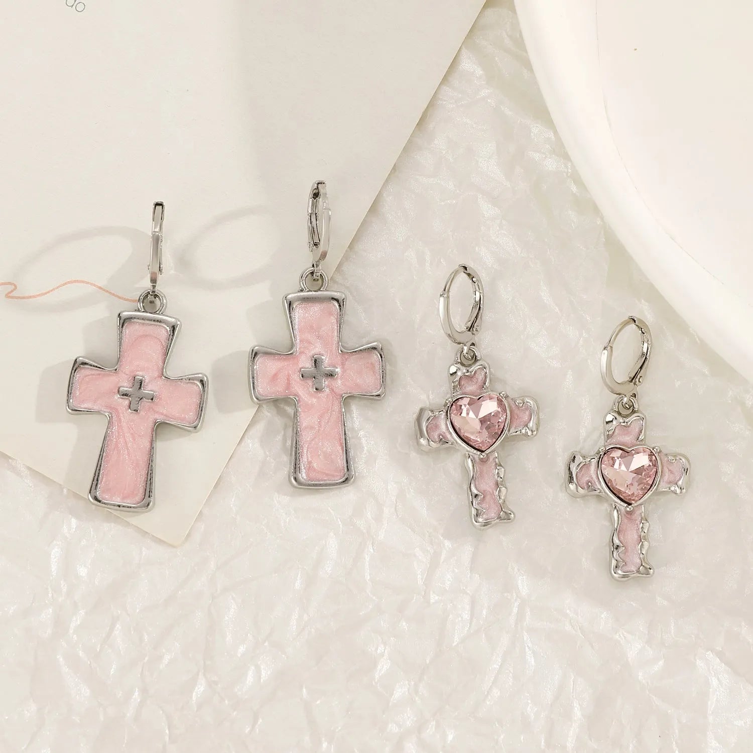 Women's classic alloy earrings with crystal detailing showing cross, heart, and cat designs in neutral white and silver colours