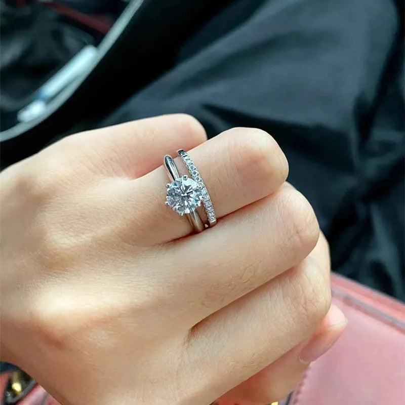 A pair of heart-shaped silver couple's rings with dragon phoenix decoration and an adjustable opening.