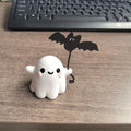 Small resin ghost walking dog statue with a bat, a Halloween decoration.