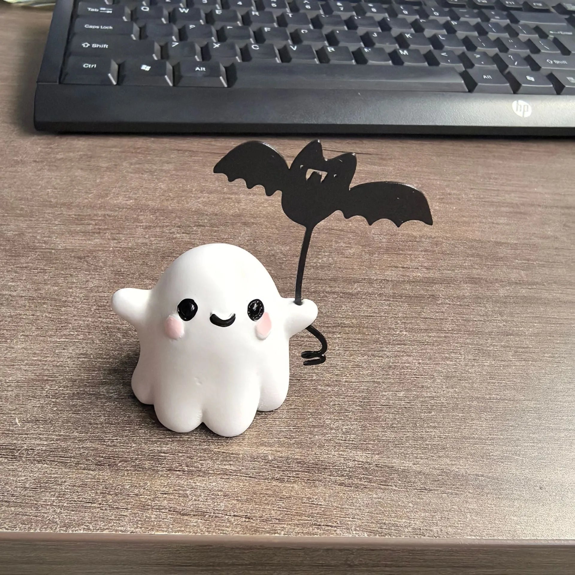 Small resin ghost walking dog statue with a bat, a Halloween decoration.