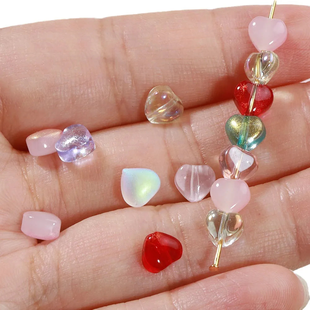 20 heart-patterned Czech beads in aurora colours including purple, blue rose, and white