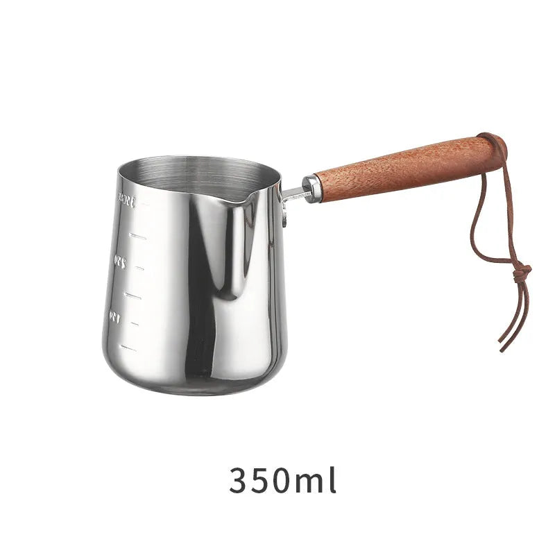 Stainless steel measuring milk cup with wooden handle showing scale markings.