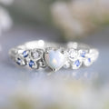 Women's peach-coloured heart-shaped alloy ring with floral and opal ocean detailing.