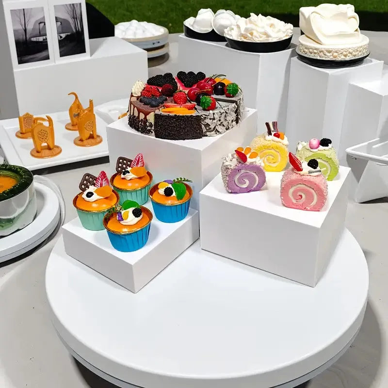 White plastic modular dessert display stand with six stackable suit cube racks on a table.