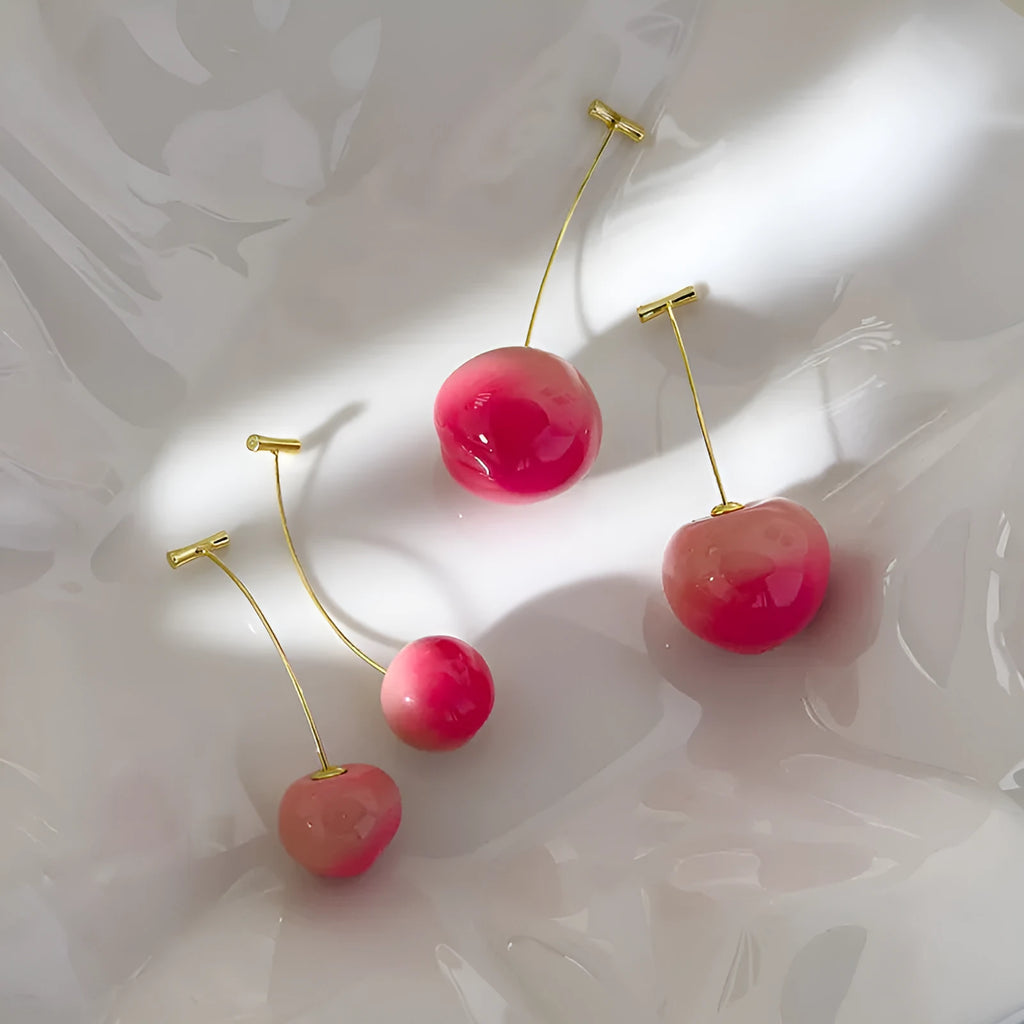 A pair of peach-shaped dangle earrings in acrylic, shown in small and large size options.