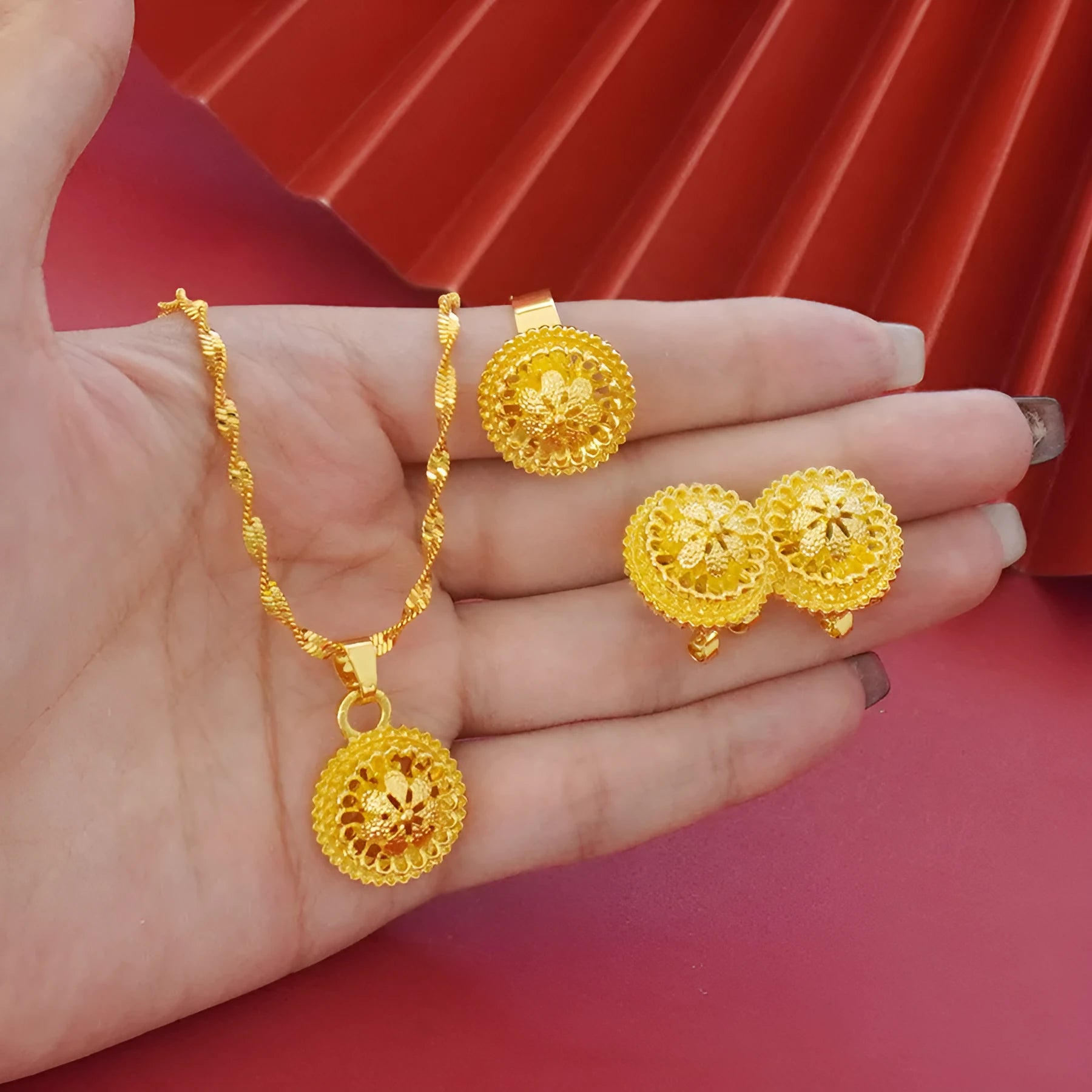 Gold-plated three-piece jewellery set with necklace, earrings, and ring featuring floral design patterns