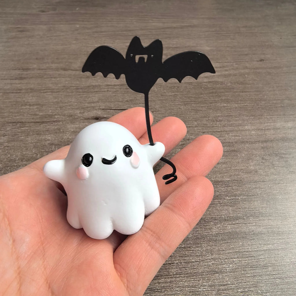 Small resin ghost walking dog statue with a bat, a Halloween decoration.