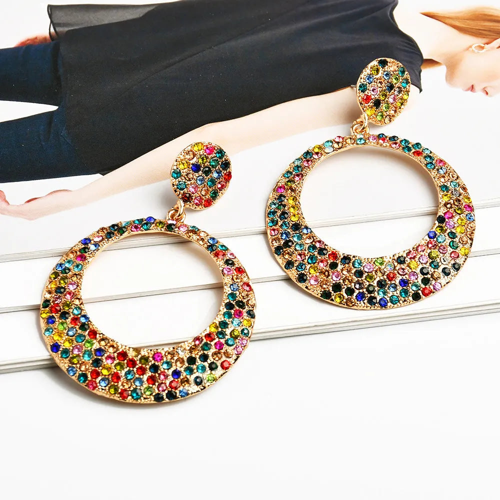 Large round cartoon-style alloy drop earrings with colourful diamond pendant on a white background.