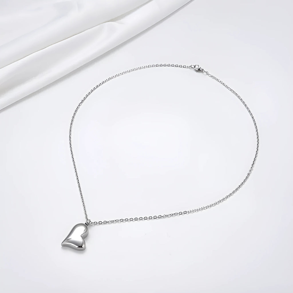 Silver curved peach heart pendant on a stainless steel necklace chain with an extension.