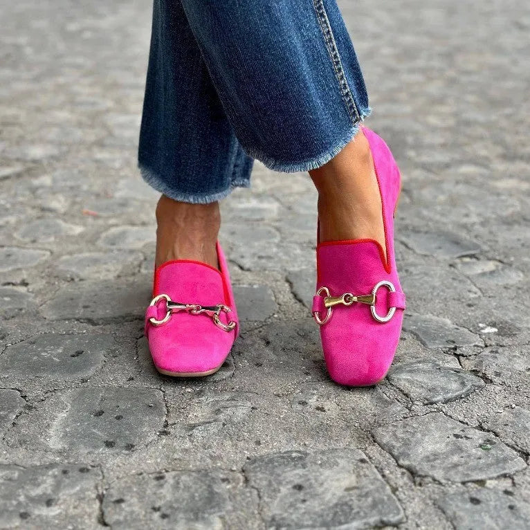 Green suede flat heel loafers with a round toe and metal fastener on the front.