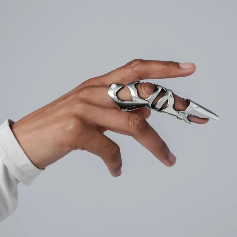 Silver-coloured alloy punk armour finger stall ring on a black background.