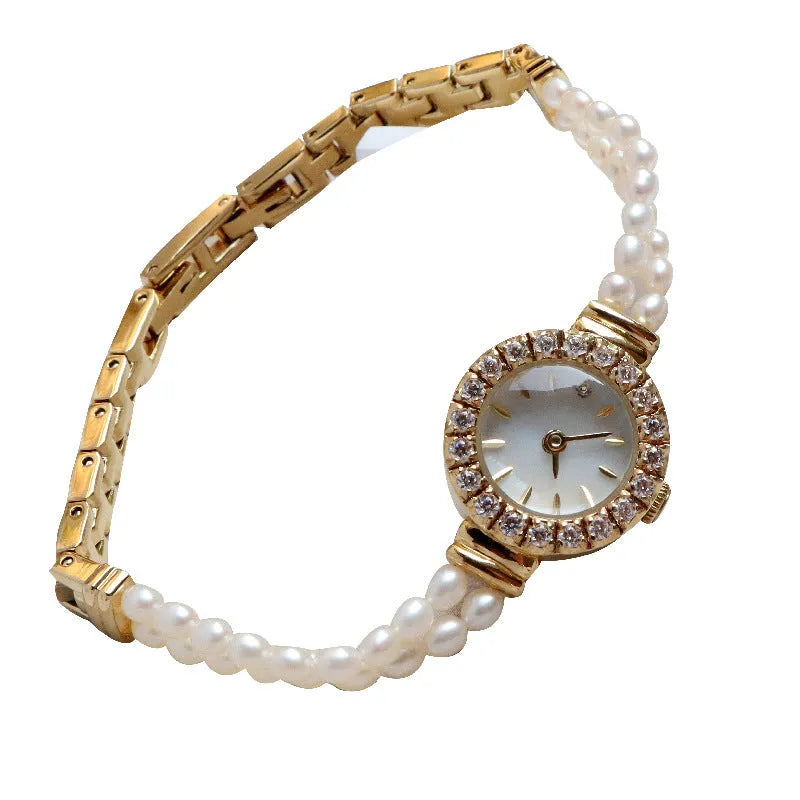 Women's light gold bracelet watch with freshwater pearls and a round 18mm dial.