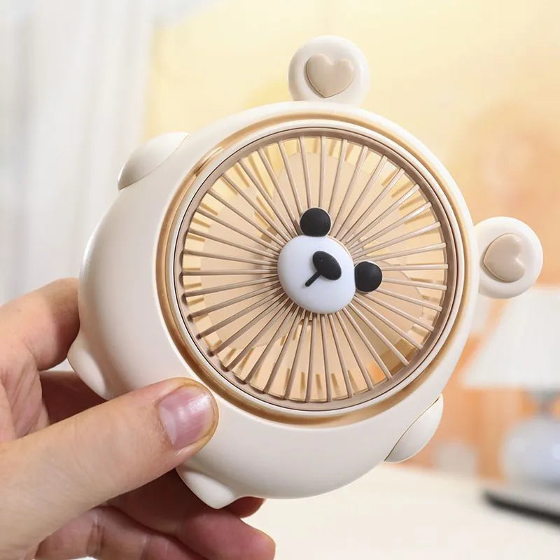 USB-powered desktop electric fan in a puppy-themed colour on a desk.