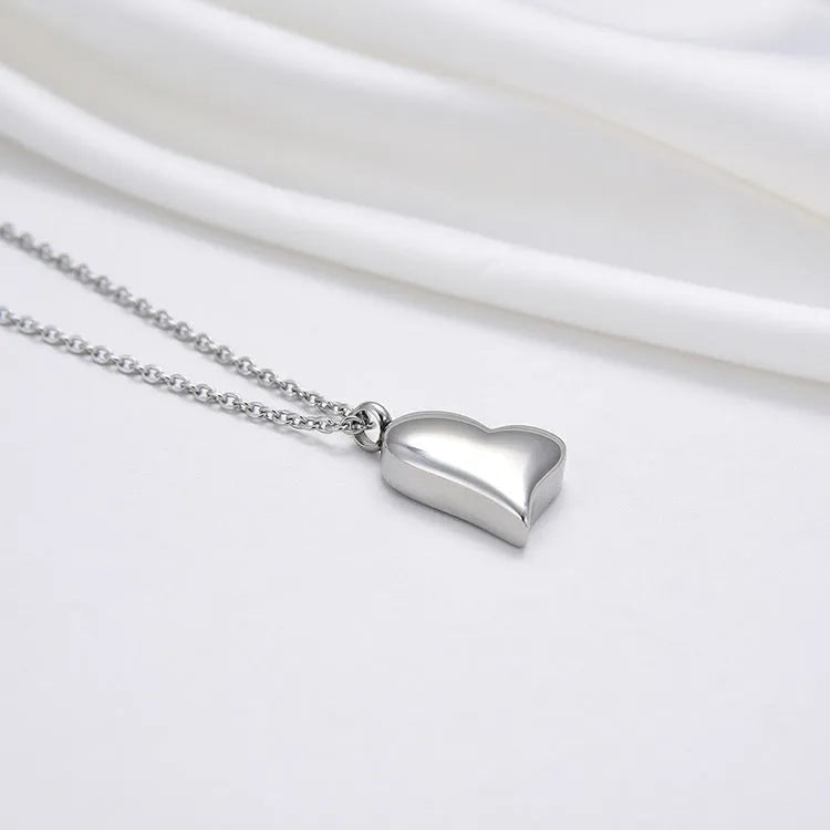 Silver curved peach heart pendant on a stainless steel necklace chain with an extension.