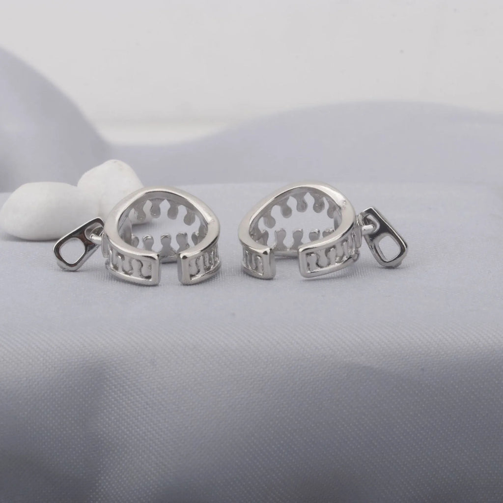 A pair of geometric copper clip-on earrings with linear design details and a zipper ear clip fastening.