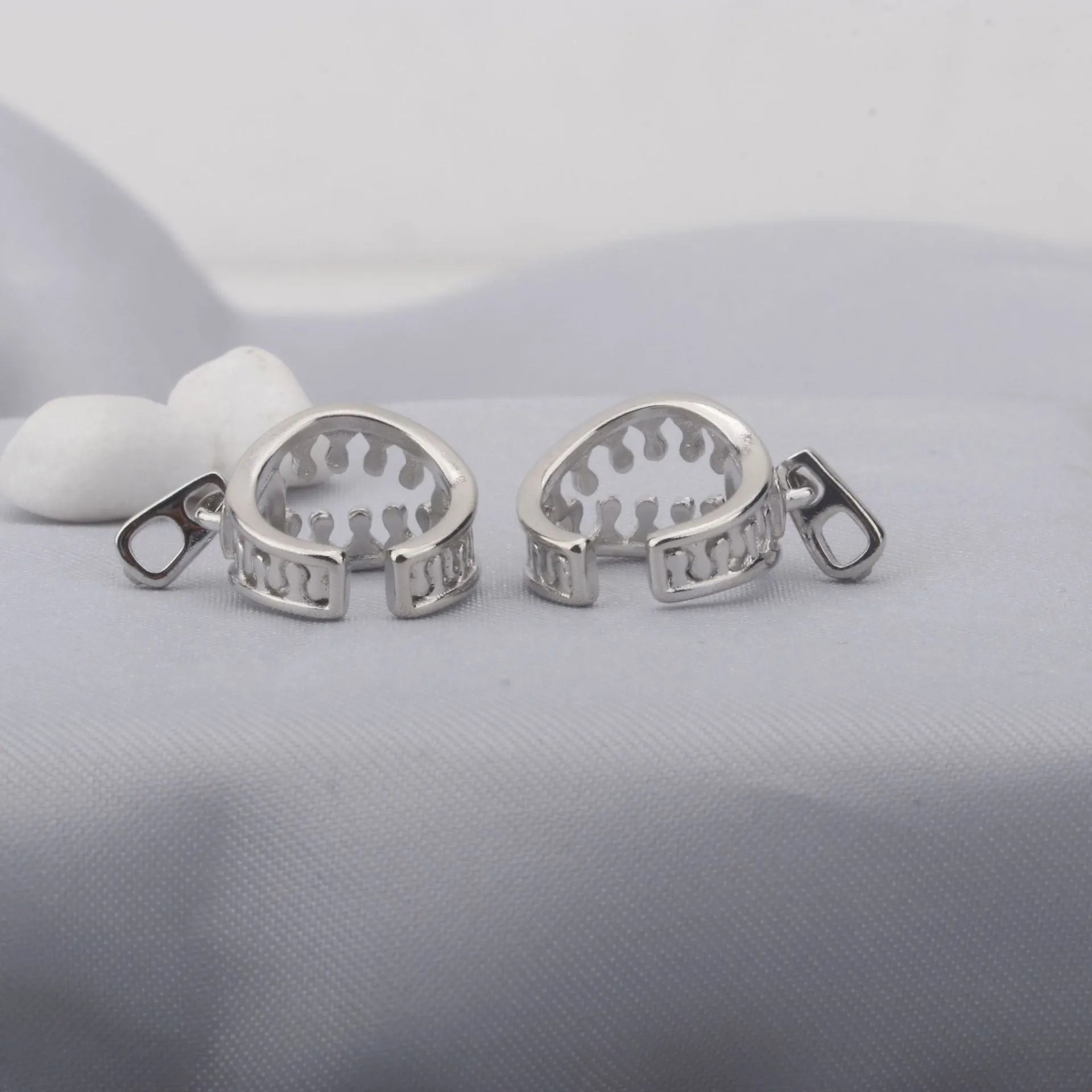 A pair of geometric copper clip-on earrings with linear design details and a zipper ear clip fastening.