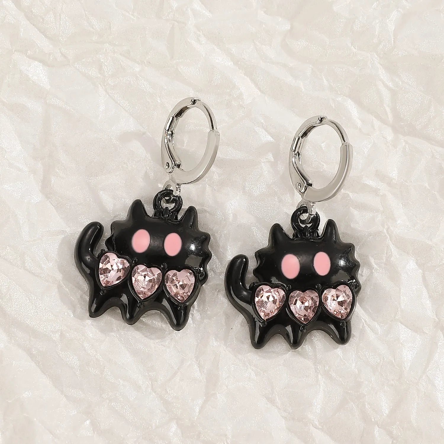 Women's classic alloy earrings with crystal detailing showing cross, heart, and cat designs in neutral white and silver colours