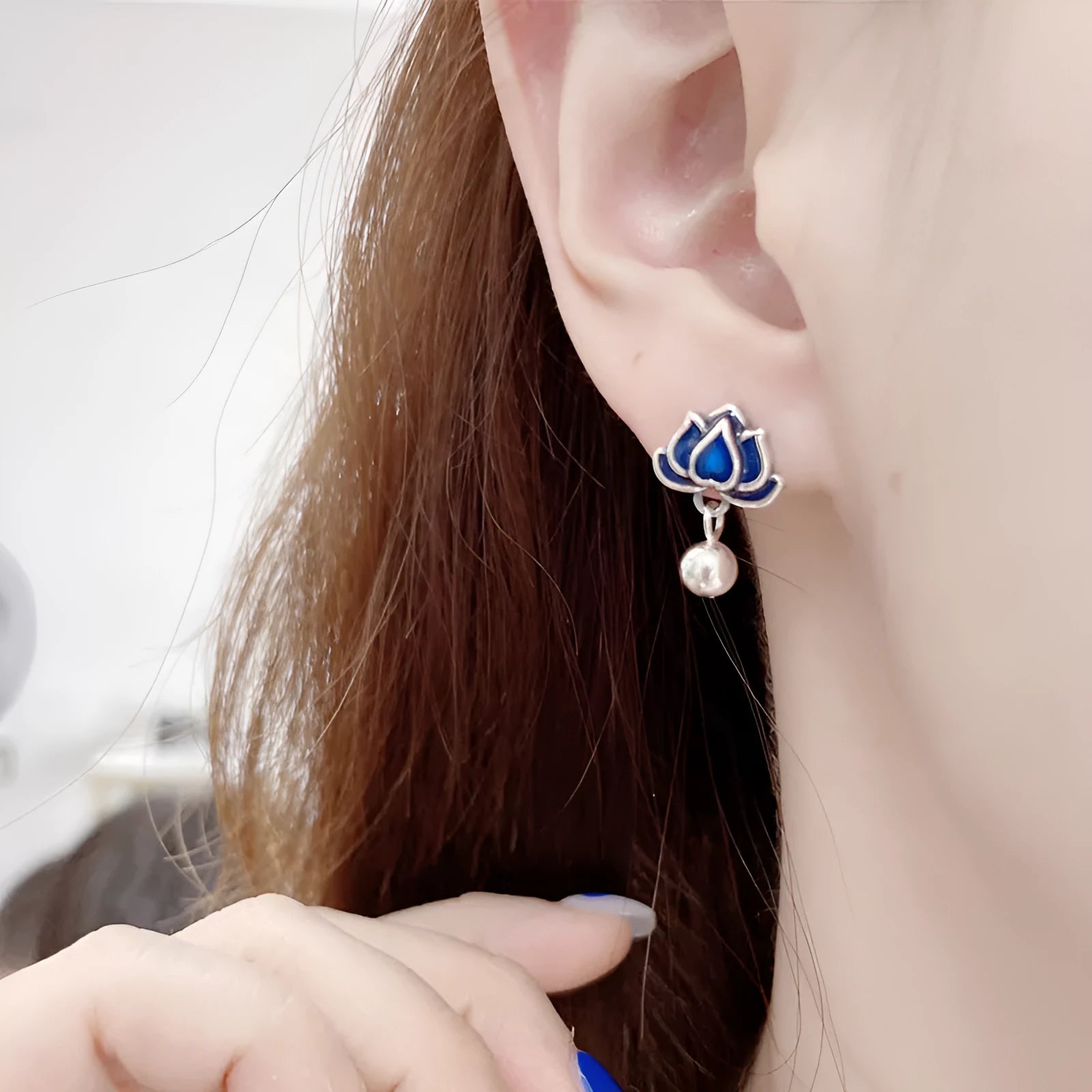 Blue alloy lotus flower ear studs with a seedpod tassel on silver posts.