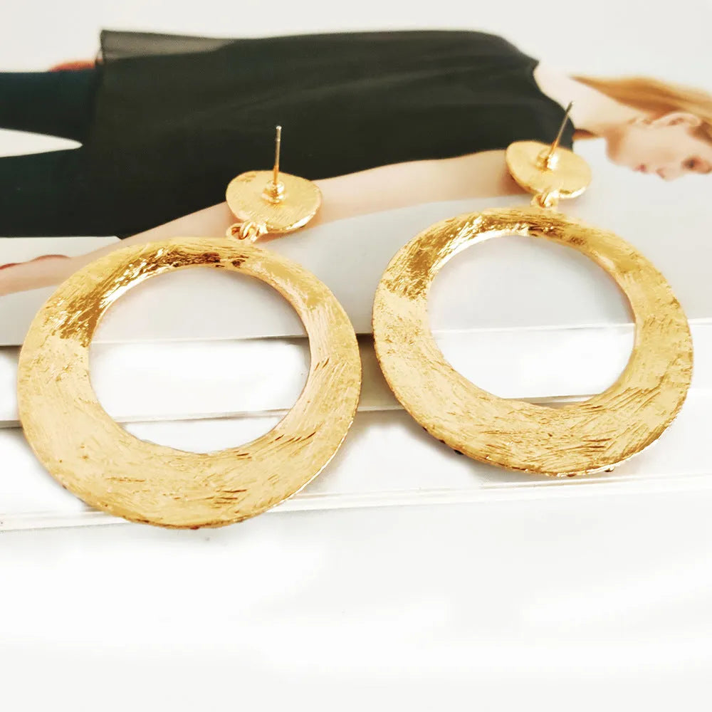 Large round cartoon-style alloy drop earrings with colourful diamond pendant on a white background.