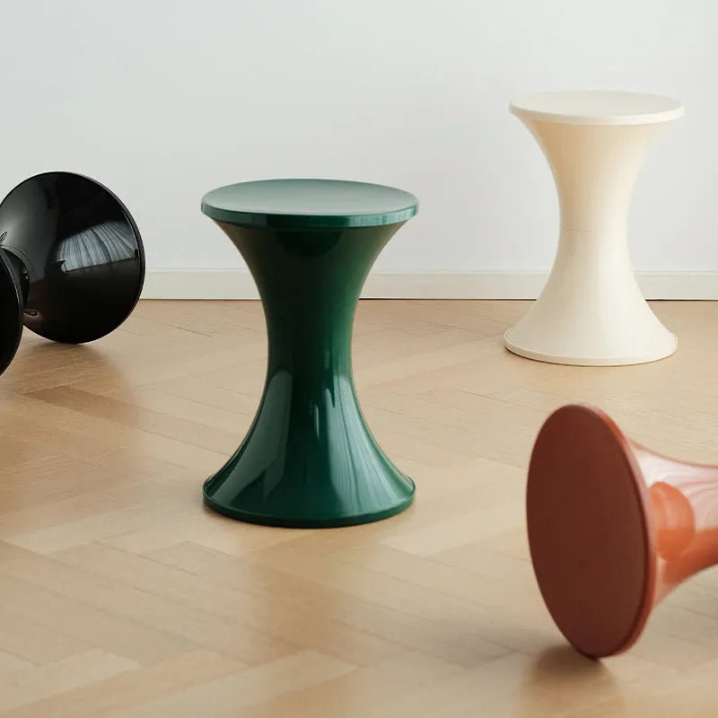 Hourglass-shaped plastic shoe changing stool with a storage seat, shown in green colour.