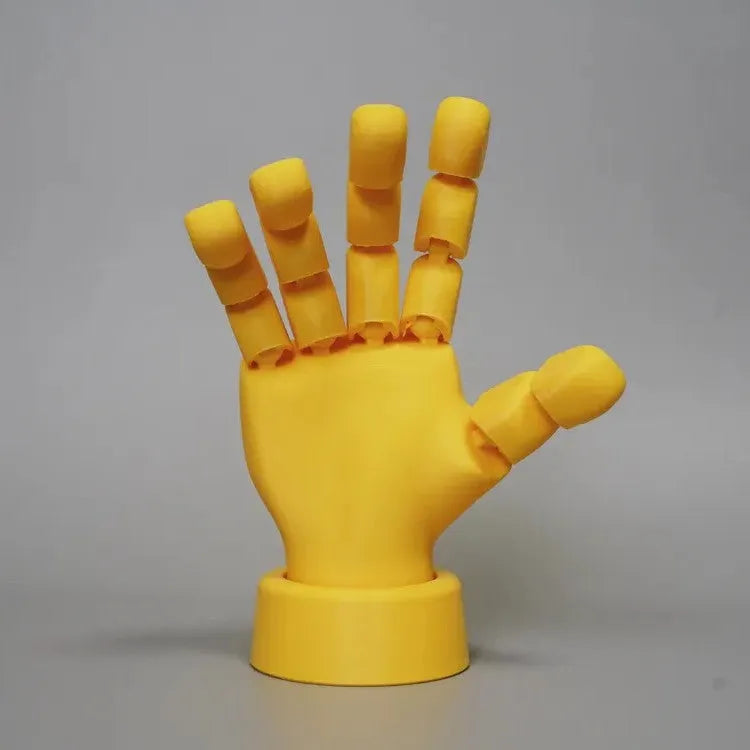 Yellow articulated PLA hand prop with movable fingers on a neutral background.