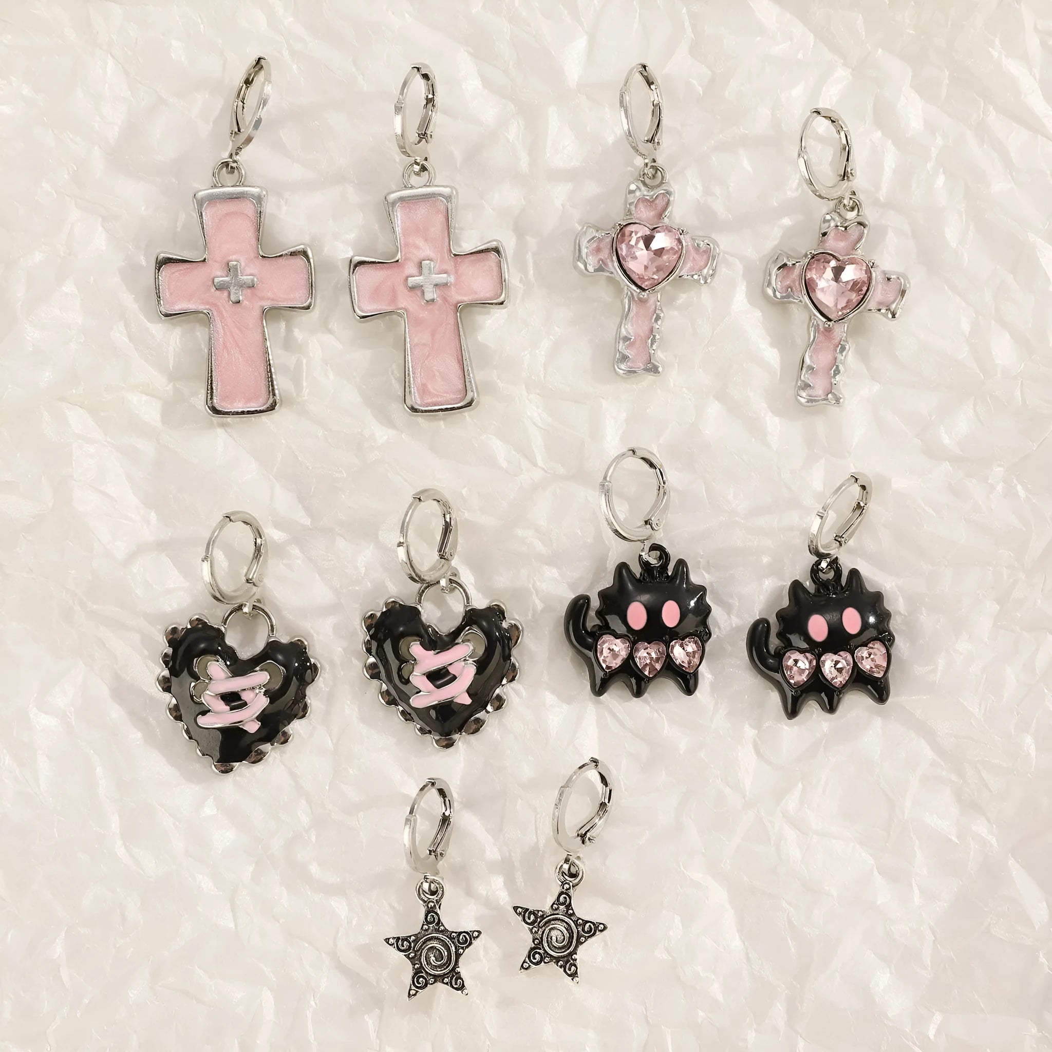 Women's classic alloy earrings with crystal detailing showing cross, heart, and cat designs in neutral white and silver colours