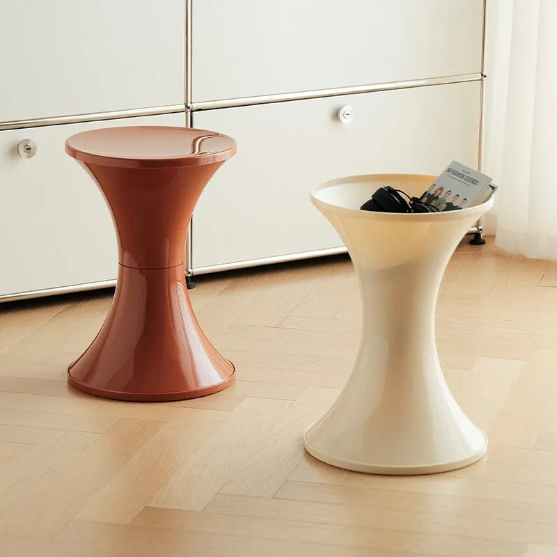 Hourglass-shaped plastic shoe changing stool with a storage seat, shown in green colour.