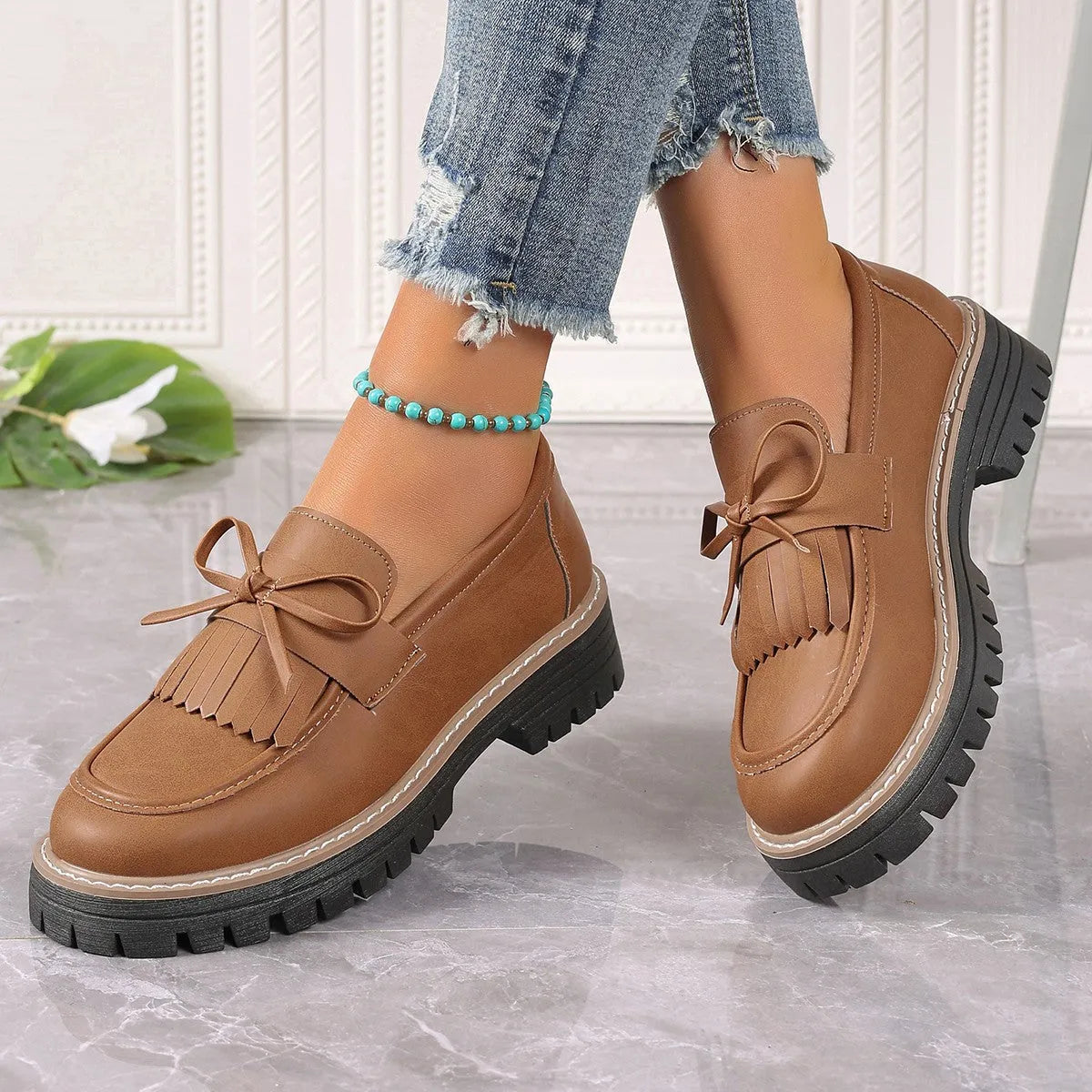 Black plus size women's loafers with a tassel and bowknot on a round toe, low top design.