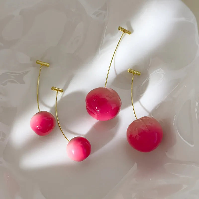 A pair of peach-shaped dangle earrings in acrylic, shown in small and large size options.