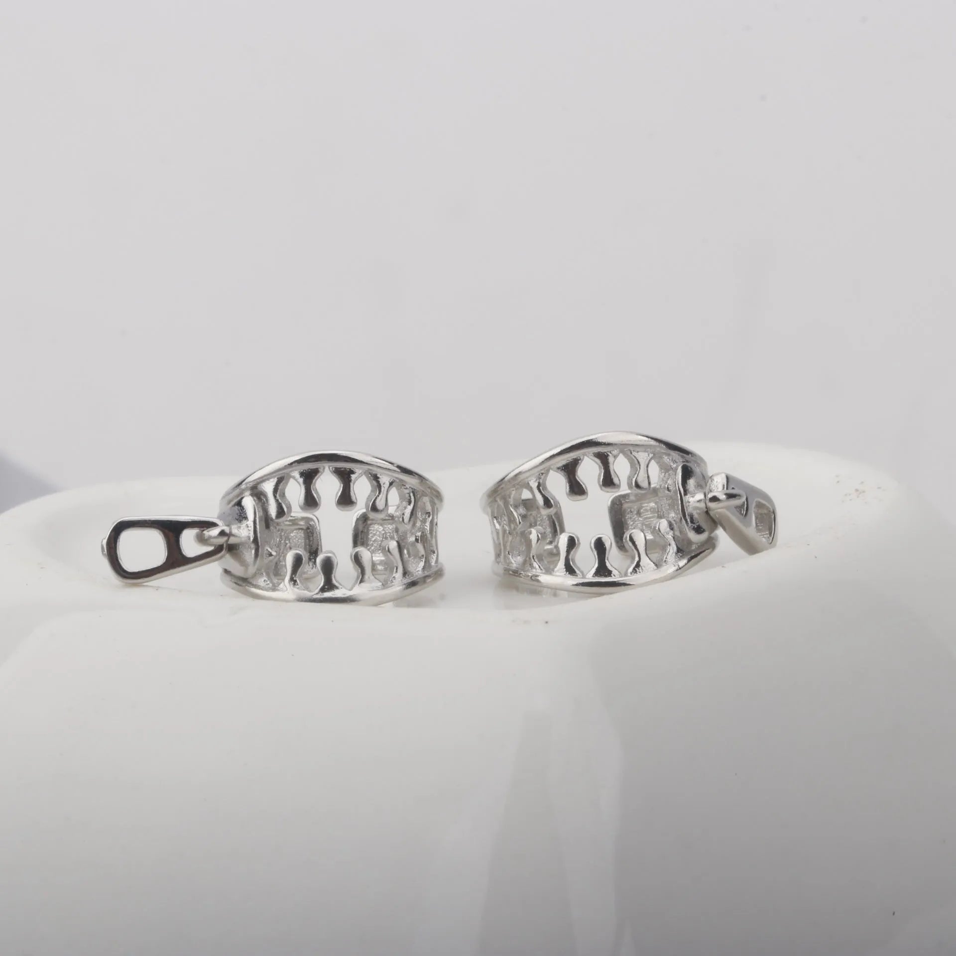 A pair of geometric copper clip-on earrings with linear design details and a zipper ear clip fastening.