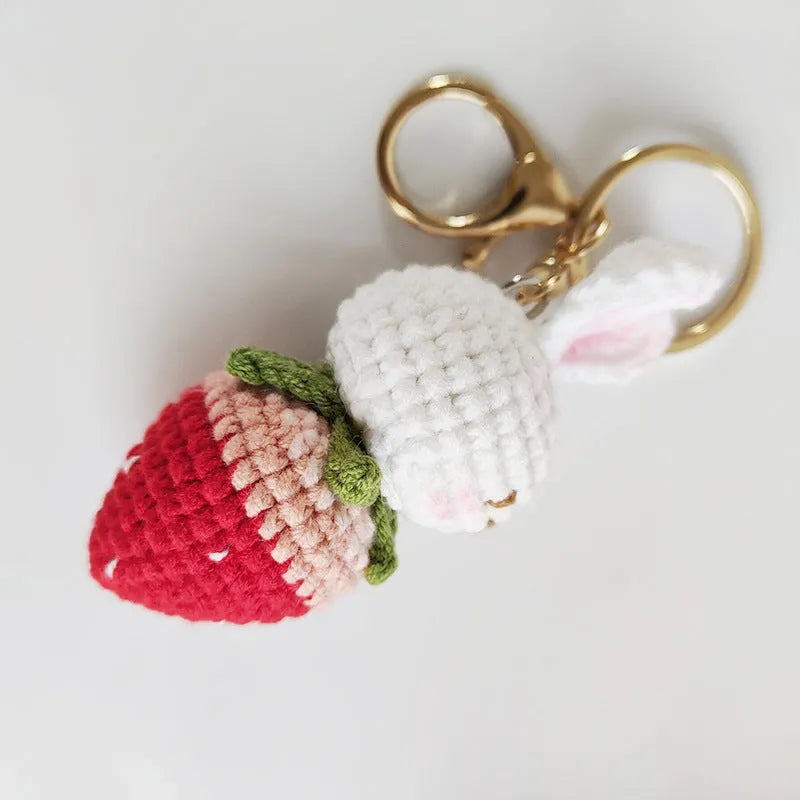 White hand-woven wire pendant with cartoon rabbit and strawberry design, shown with an integrated key.
