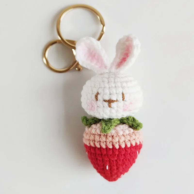 White hand-woven wire pendant with cartoon rabbit and strawberry design, shown with an integrated key.