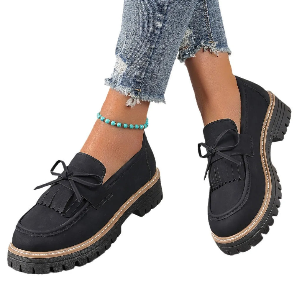 Black plus size women's loafers with a tassel and bowknot on a round toe, low top design.
