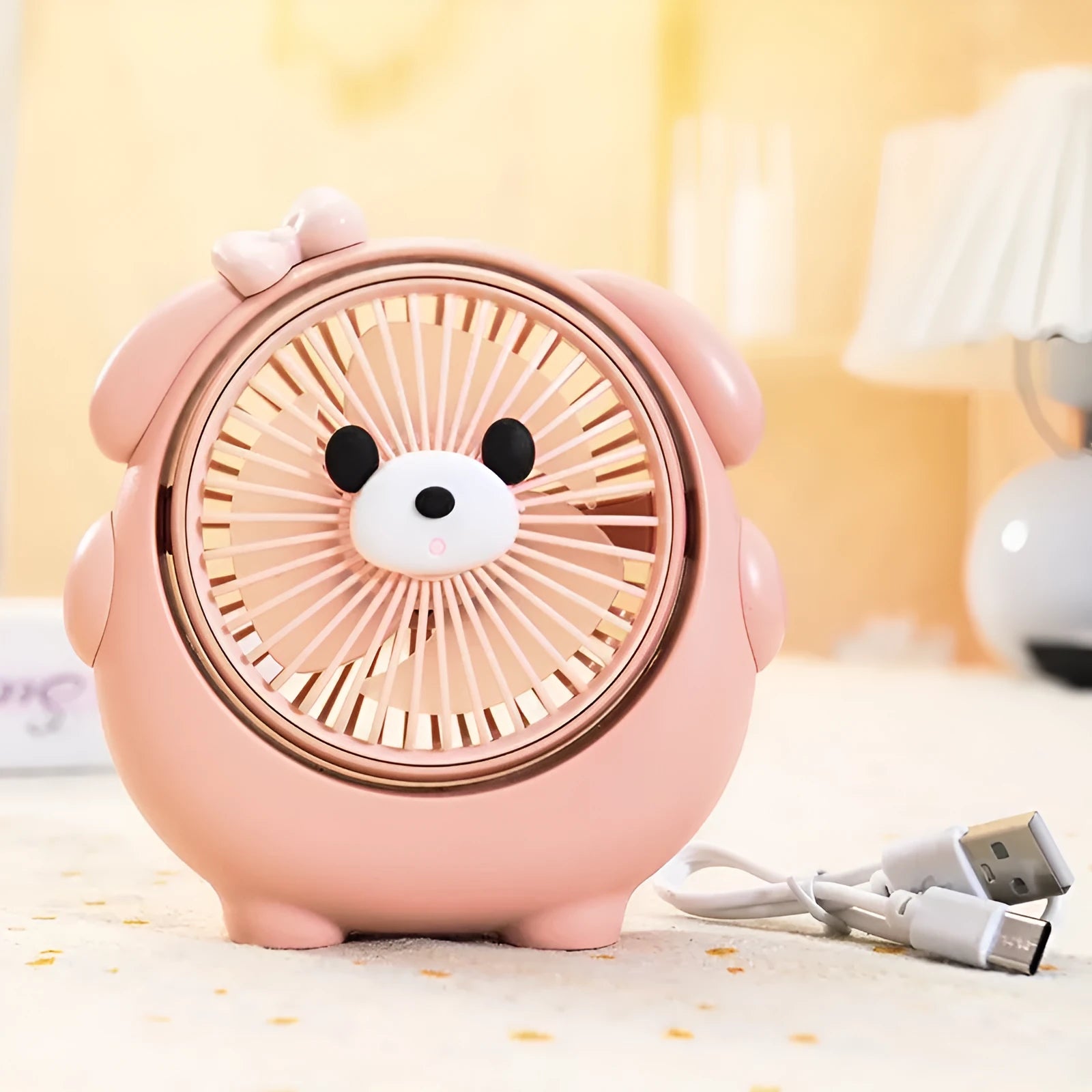 USB-powered desktop electric fan in a puppy-themed colour on a desk.