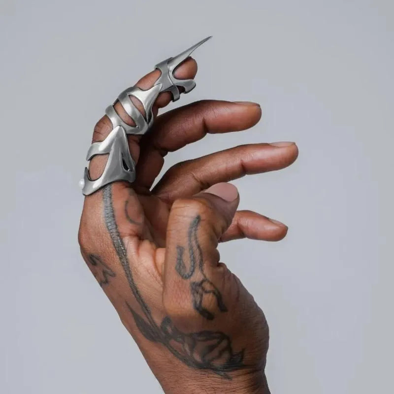 Silver-coloured alloy punk armour finger stall ring on a black background.