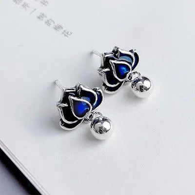 Blue alloy lotus flower ear studs with a seedpod tassel on silver posts.