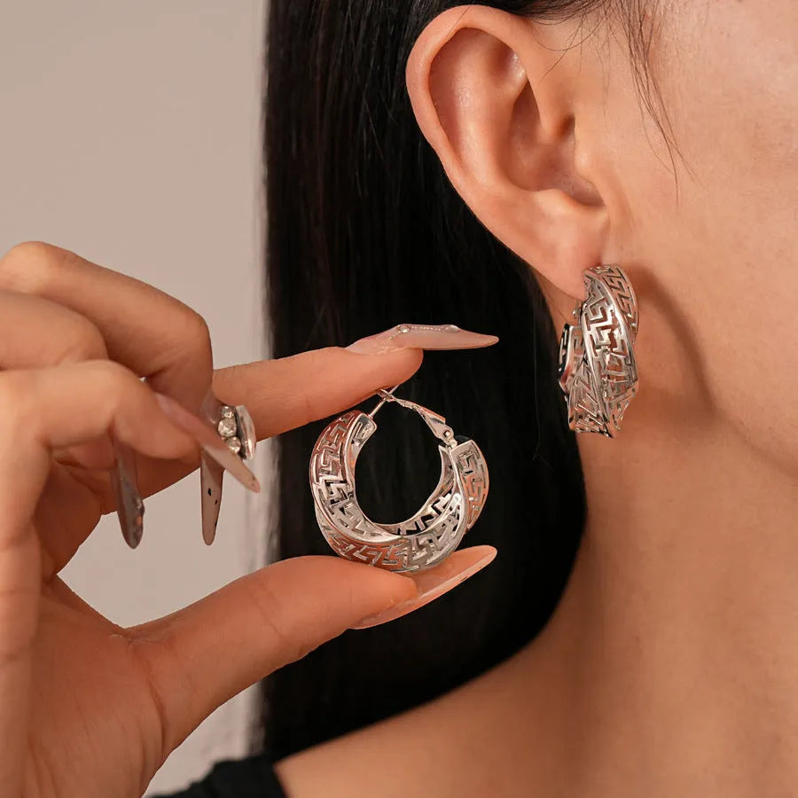 Twisted geometric hollow stud earrings in gold or silver finish with exaggerated round design