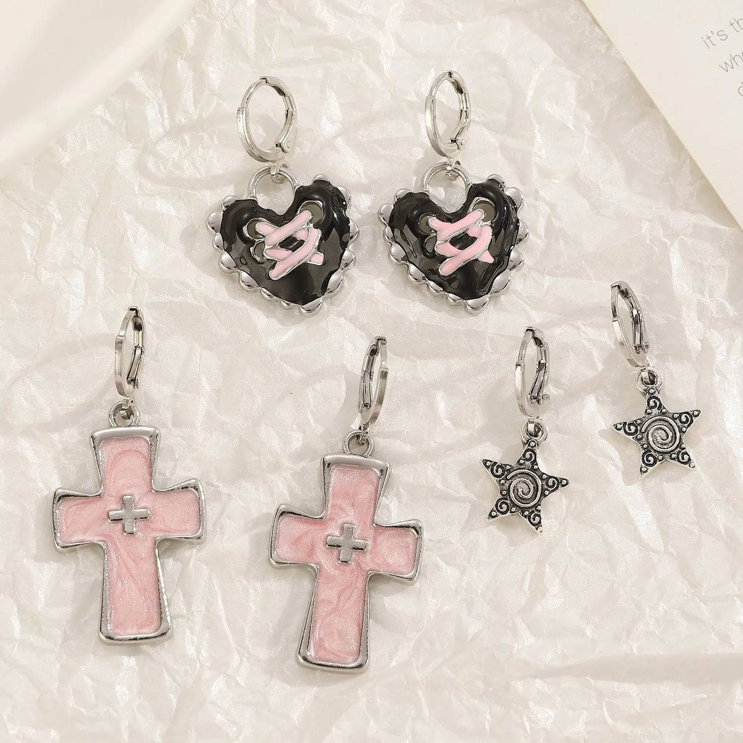 Women's classic alloy earrings with crystal detailing showing cross, heart, and cat designs in neutral white and silver colours