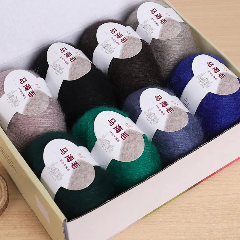 A ball of mohair yarn for a hand-woven DIY scarf kit, shown with a selection of its 34 colour options.