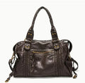 Women's European retro motorcycle messenger bag in bright black with golden edge showing weaving details and shoulder strap